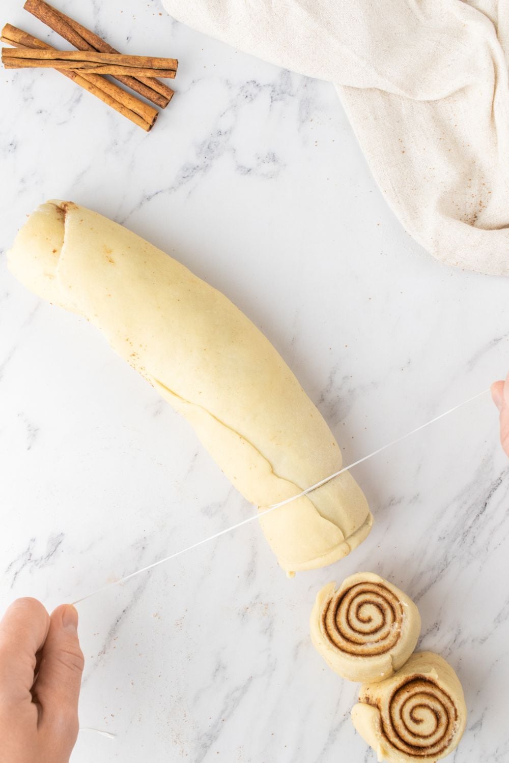 slicing cinnamon rolls on marble counter