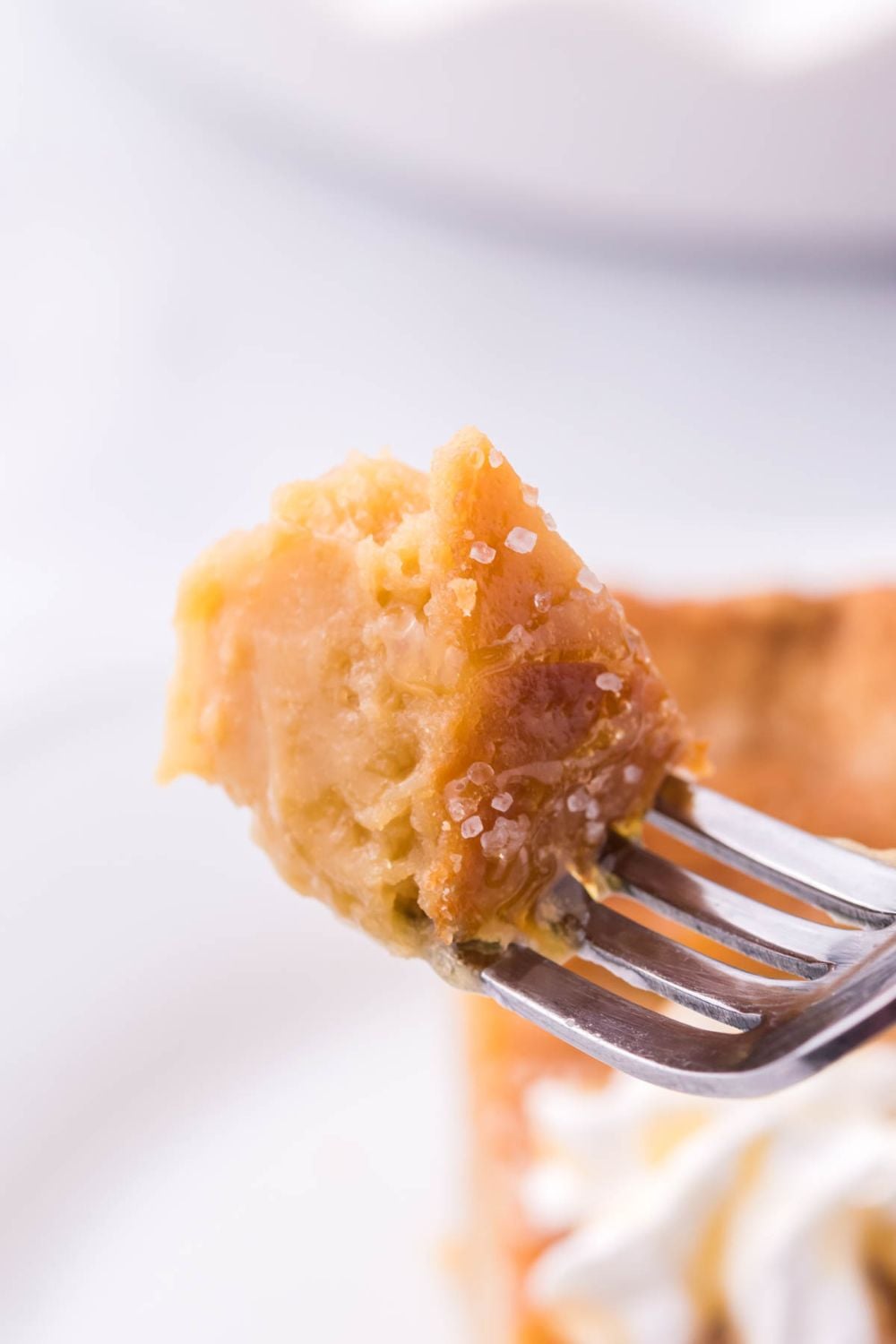 fork with honey pie on it above plate with a slice of pie
