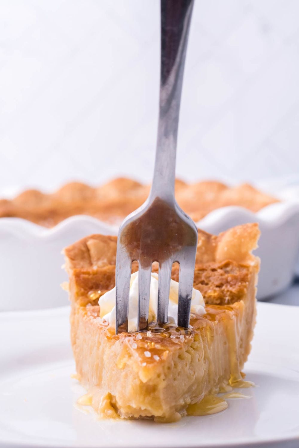 fork in a slice of pie on a plate on table