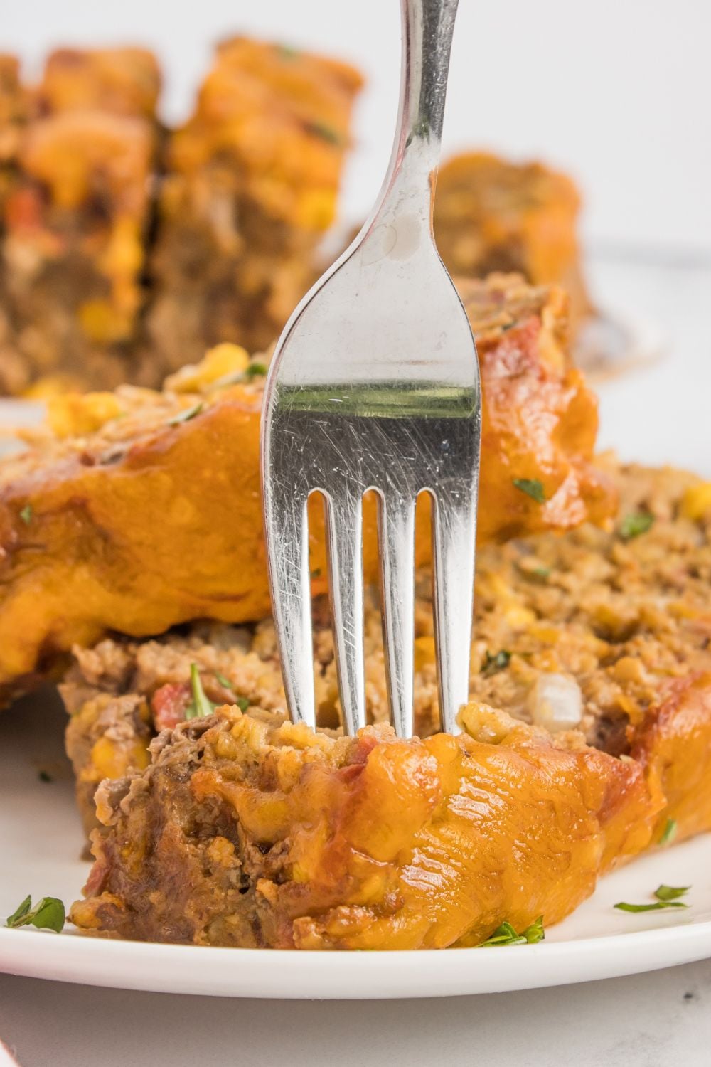 meatloaf on plate with a fork poking in the meat