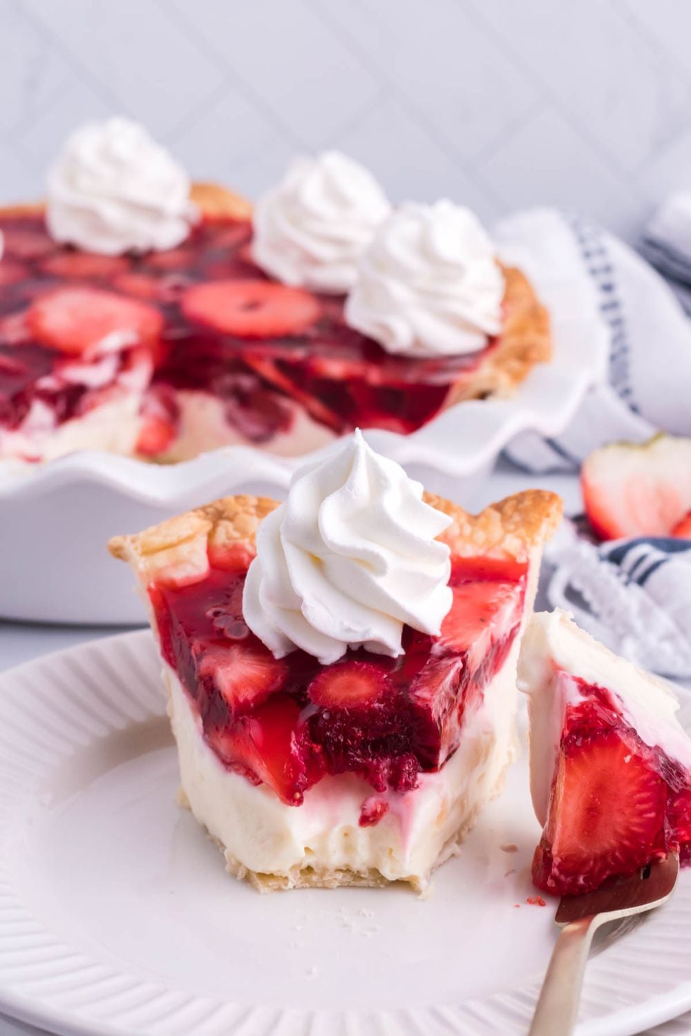 strawberry pie sliced on plate with a bite taken out of it