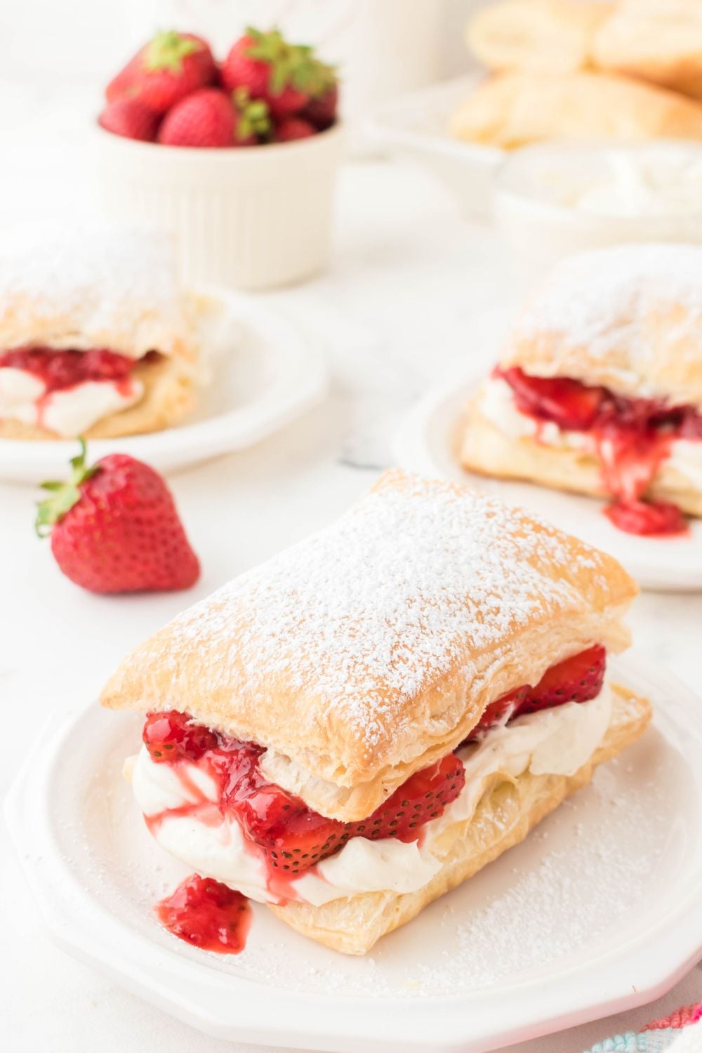 strawberry puff pastry desserts on plates around the table