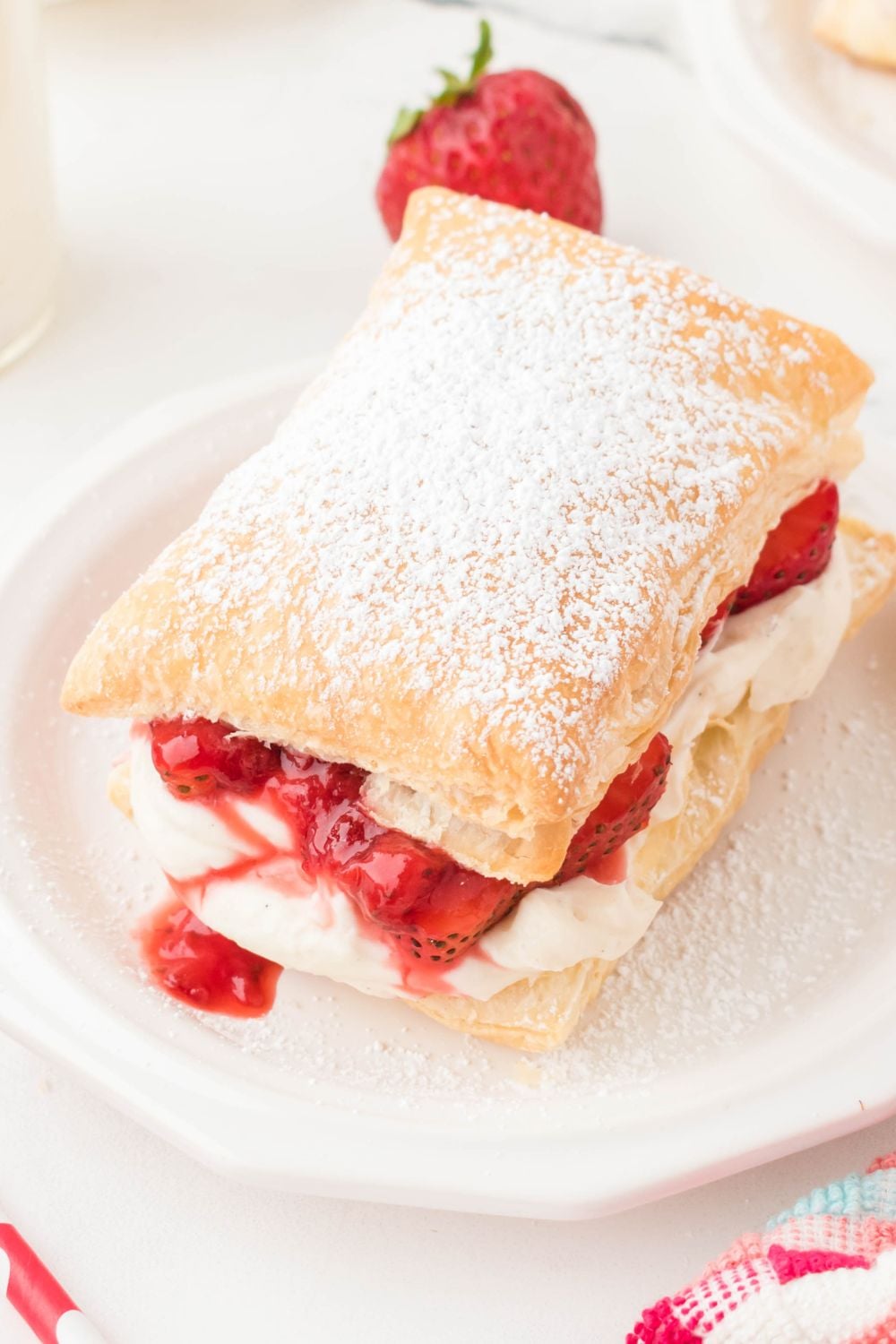 strawberry puffs pastry on plate with strawberry in the background