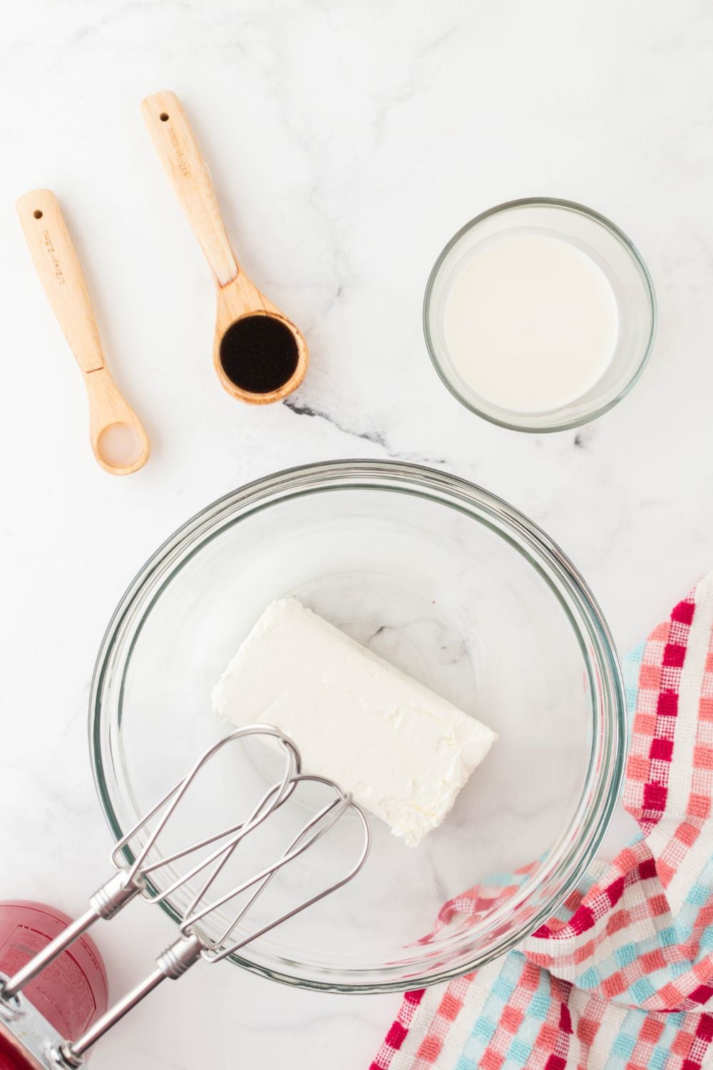 cream cheese in mixing bowl with mixer beaters in bowl