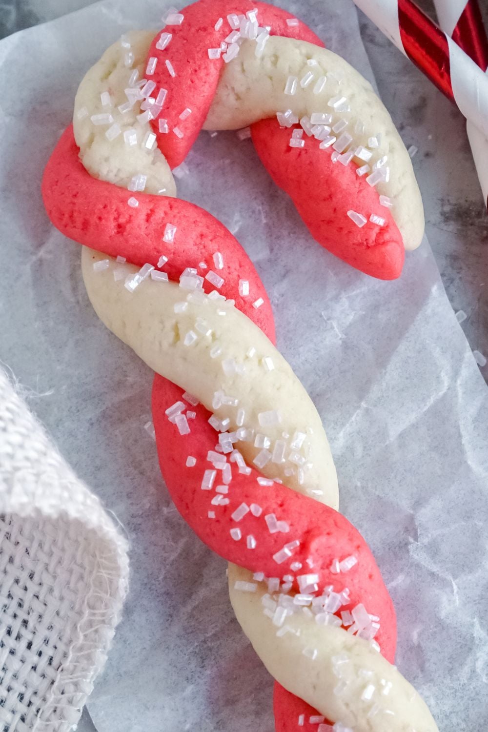 sugar cookie candy cane christmas cookie on parchment paper