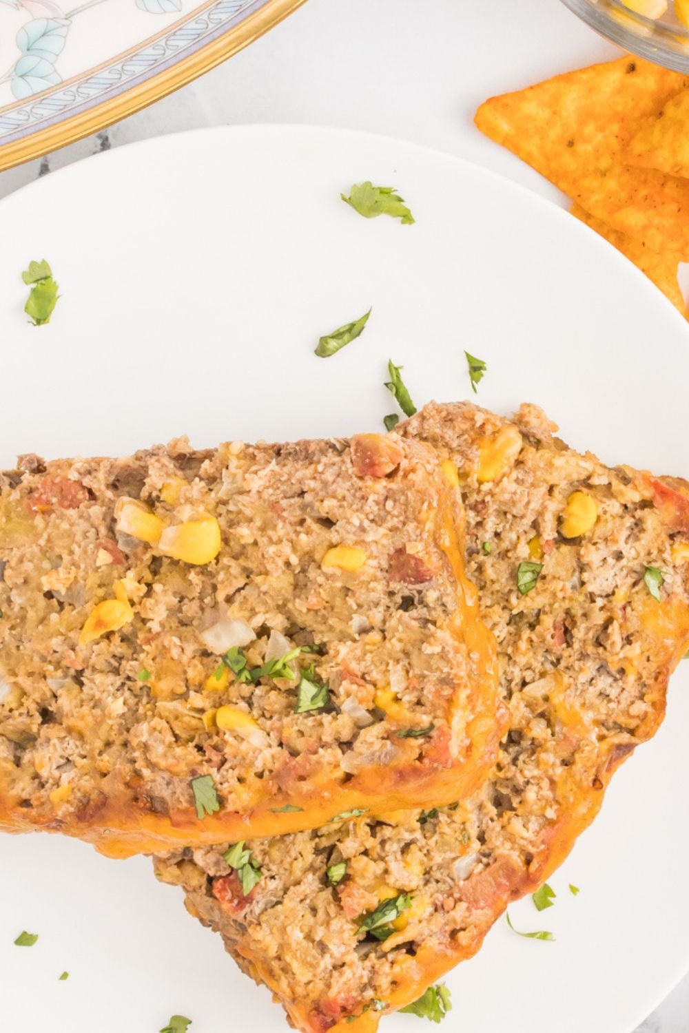 meatloaf sliced on a plate with chips around the sides of plate