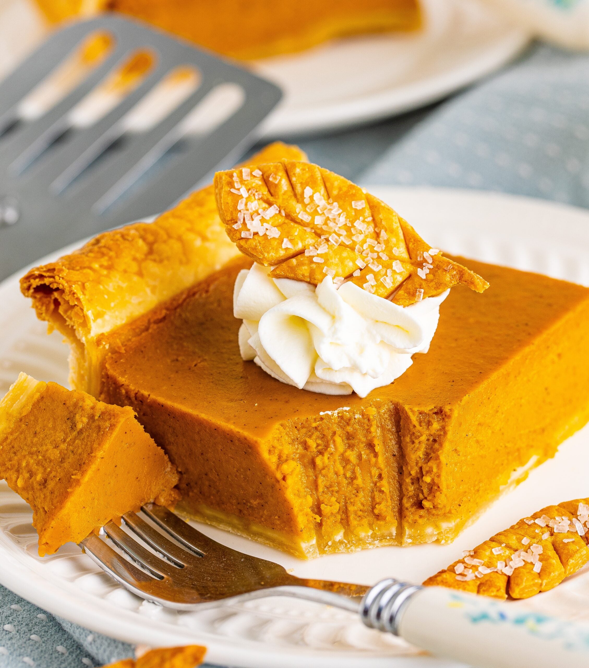 Pumpkin slab pie slice on a white plate with a bite removed on a fork