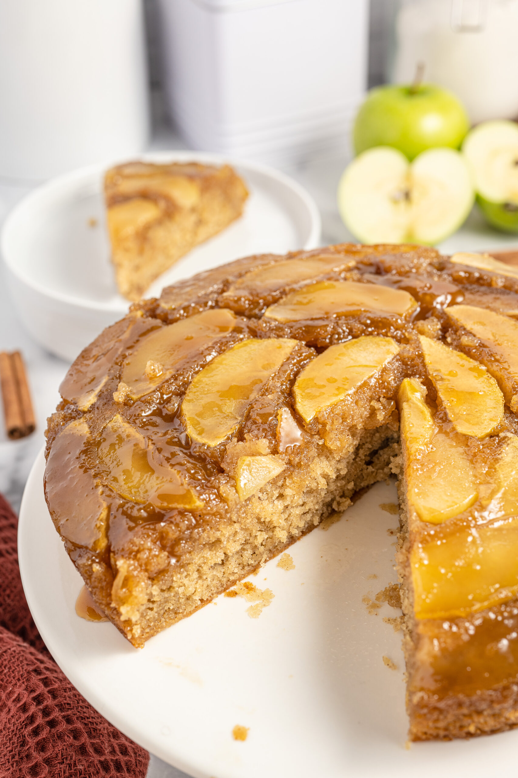 The cake on a white serving platter with a slice removed to show texture