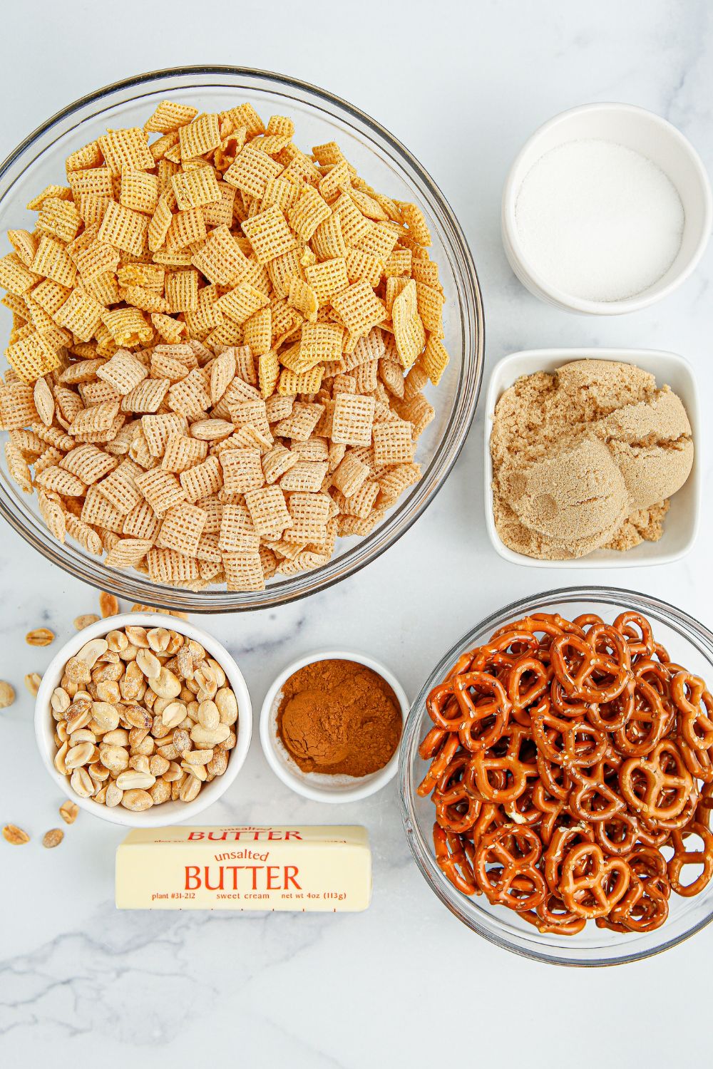 Churro Chex Mix ingredients in glass bowls on table