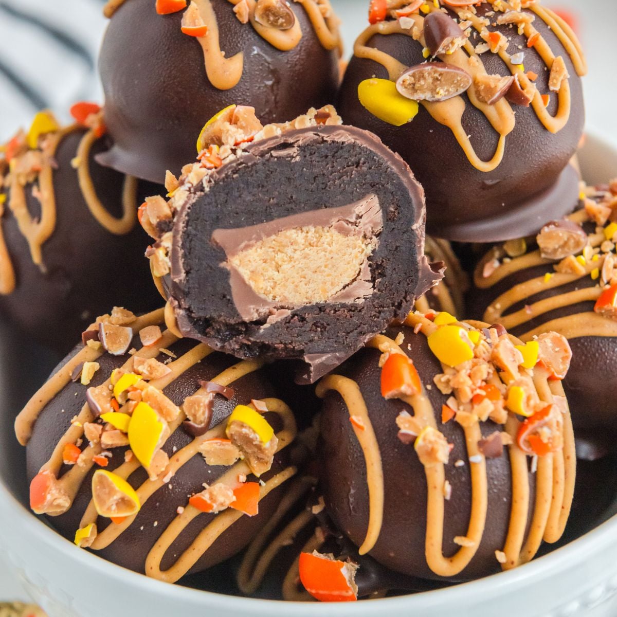 Reese's Oreo Balls in a bowl with one cut in half