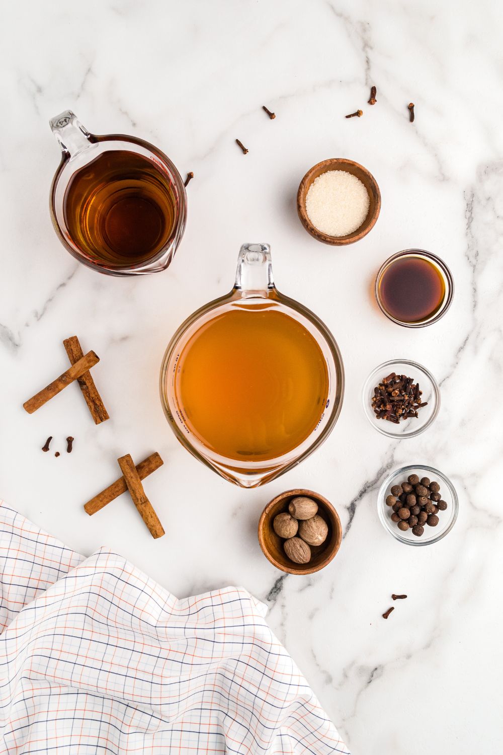 ingredients for a caramel flavored cider on table in little bowls