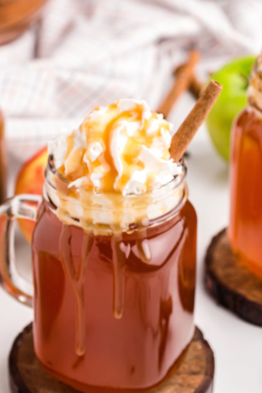 glass with caramel apple cider topped with whipped cream