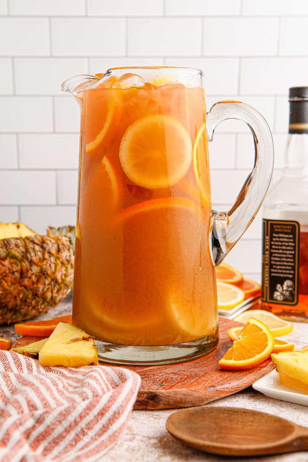 Touchdown Tea in a pitcher sitting on table with ingredients used in drink around it