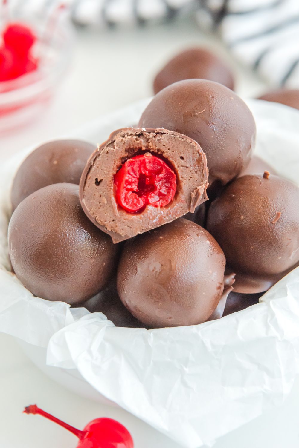 brownie bites in a bowl on table with cherries around it