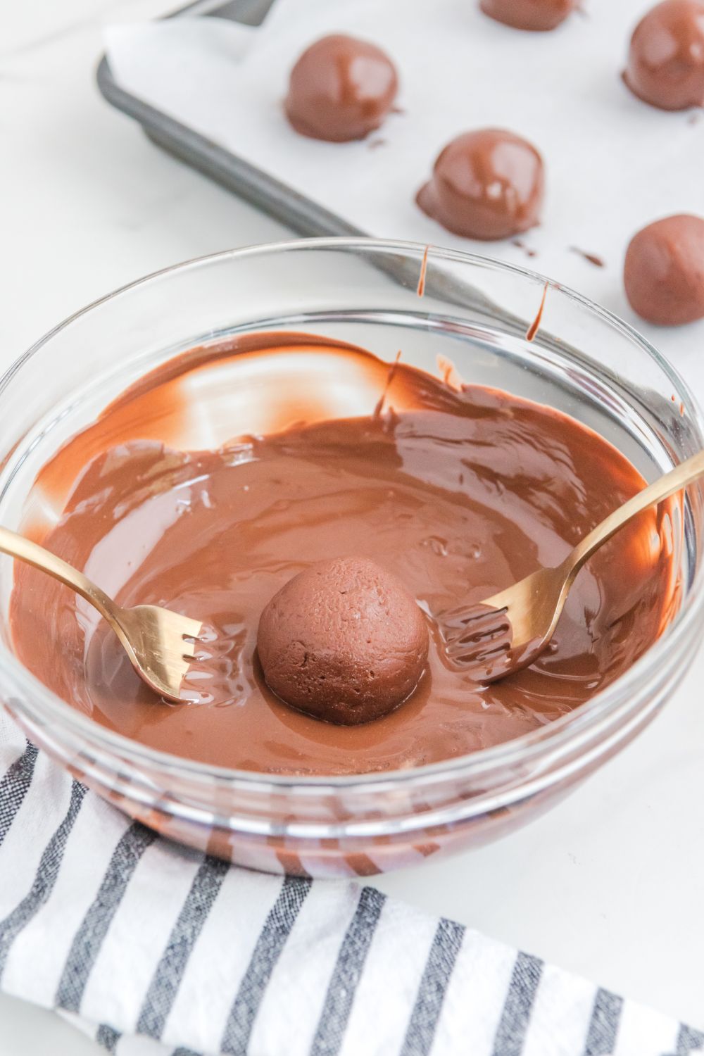 dipping a brownie ball in melted chocolate 