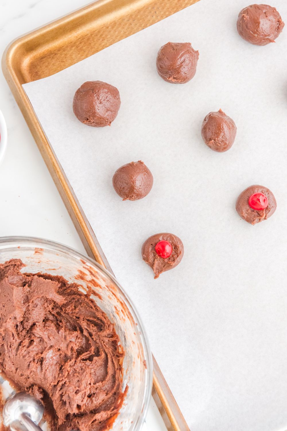 cookie sheet with brownie bites and a cherry sitting in center of balls 