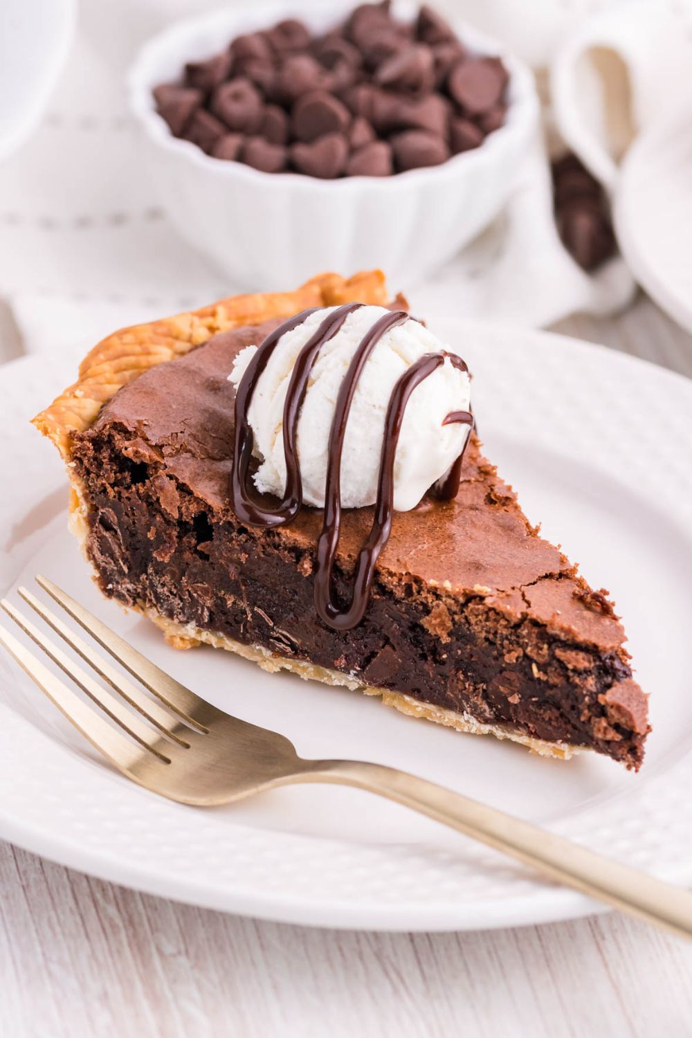 slice of pie on plate with ice cream and hot fudge drizzled on top