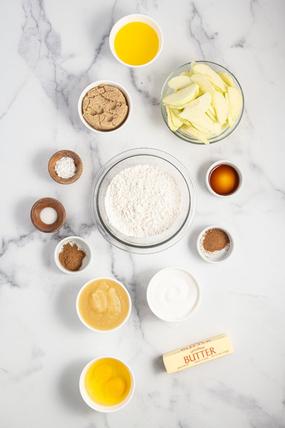 overhead shot of ingredients for an apple upside down cake in bowls on table