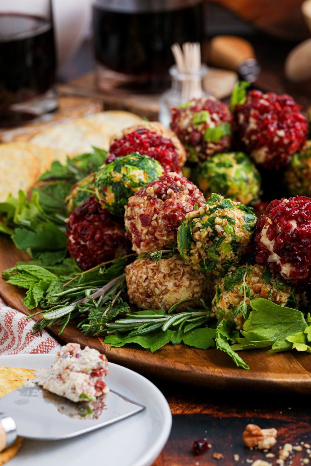 Cheese Ball Wreath on table with some cheeseballs placed on a plate