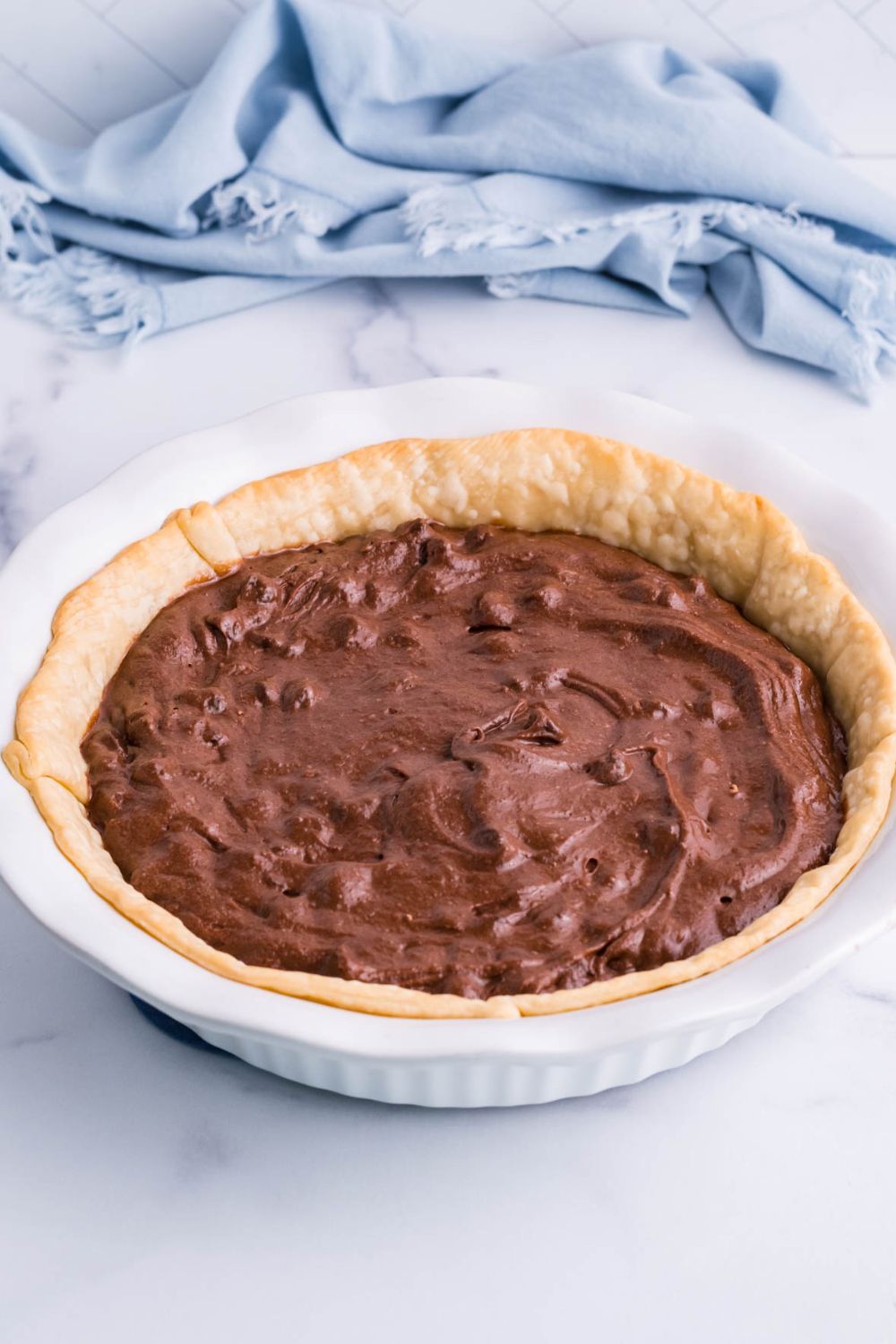 brownie batter in a pie crust on table
