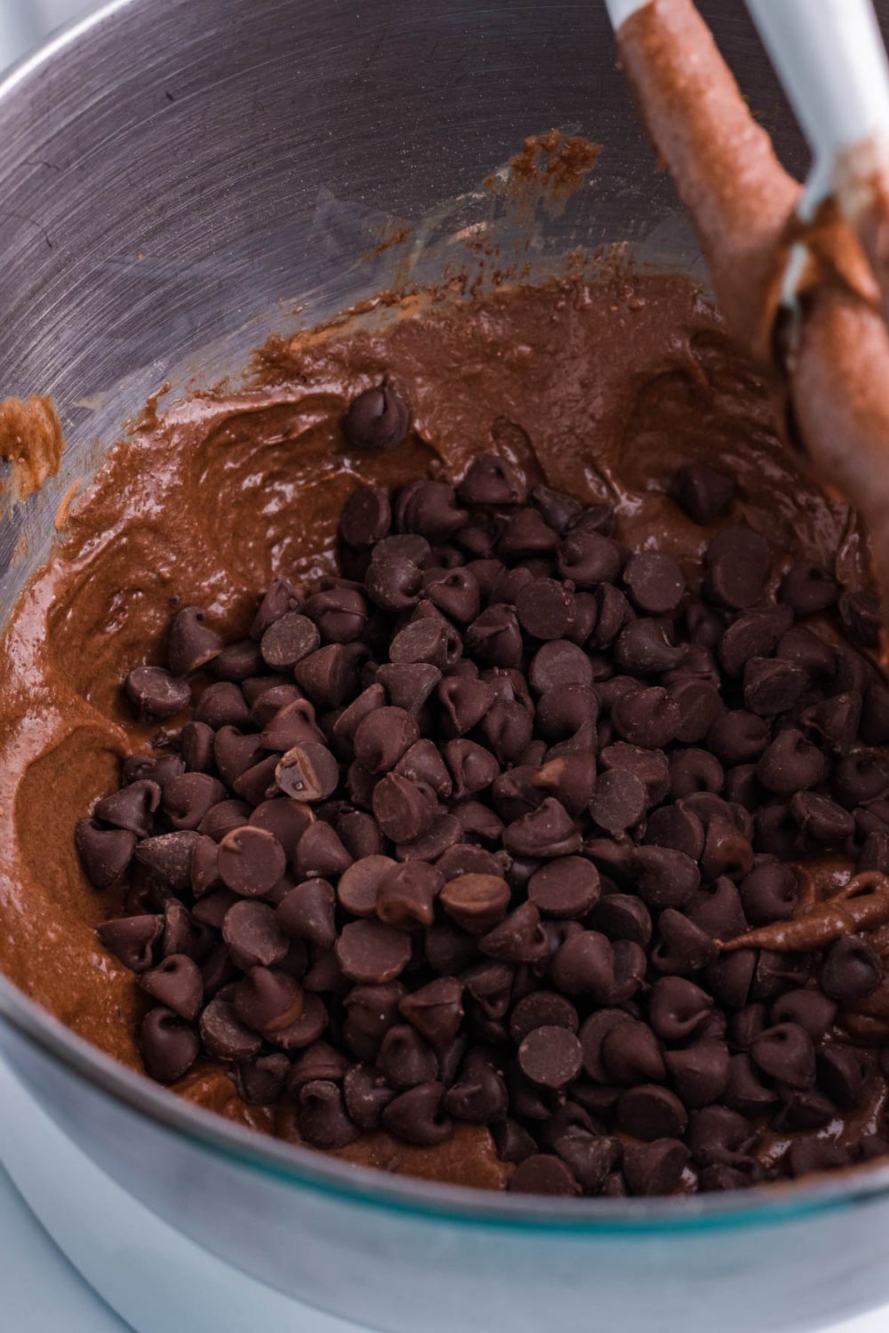 chocolate chips on top of the brownie pie batter in bowl