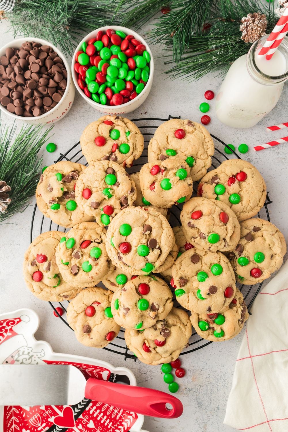 Christmas M&M Cookies on a platter with candies around it on table