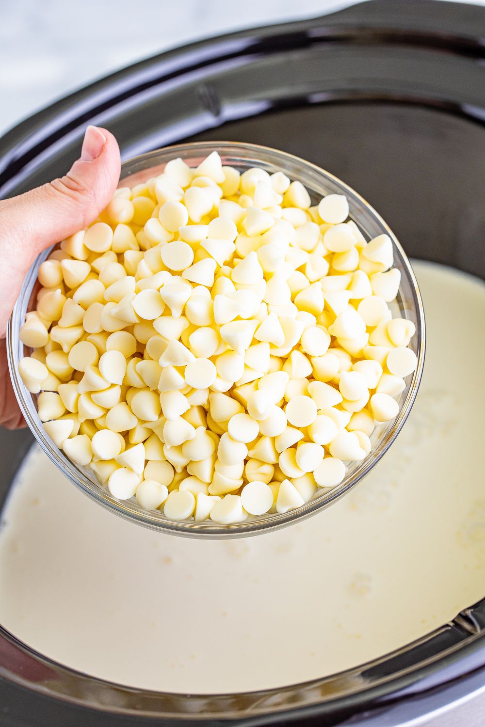 bowl of white chocolate chips above slow cooker