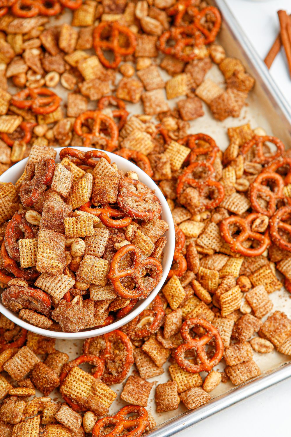 cinnamon chex mix in a try with a bowl full