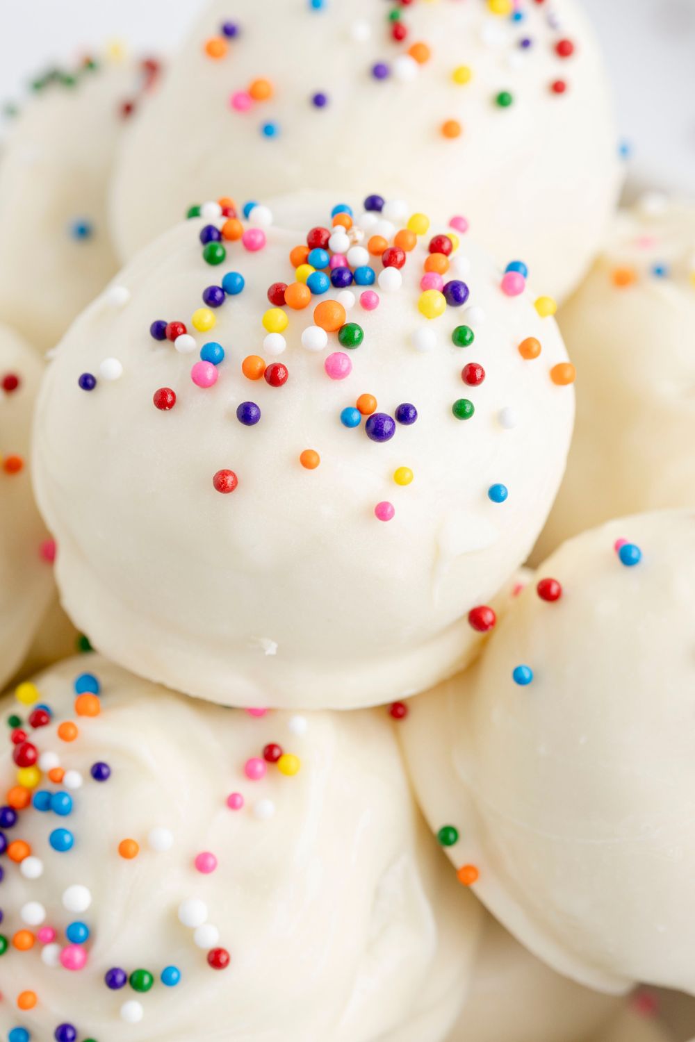 Lofthouse Sugar Cookie Truffles in a bowl stacked on top of each other 