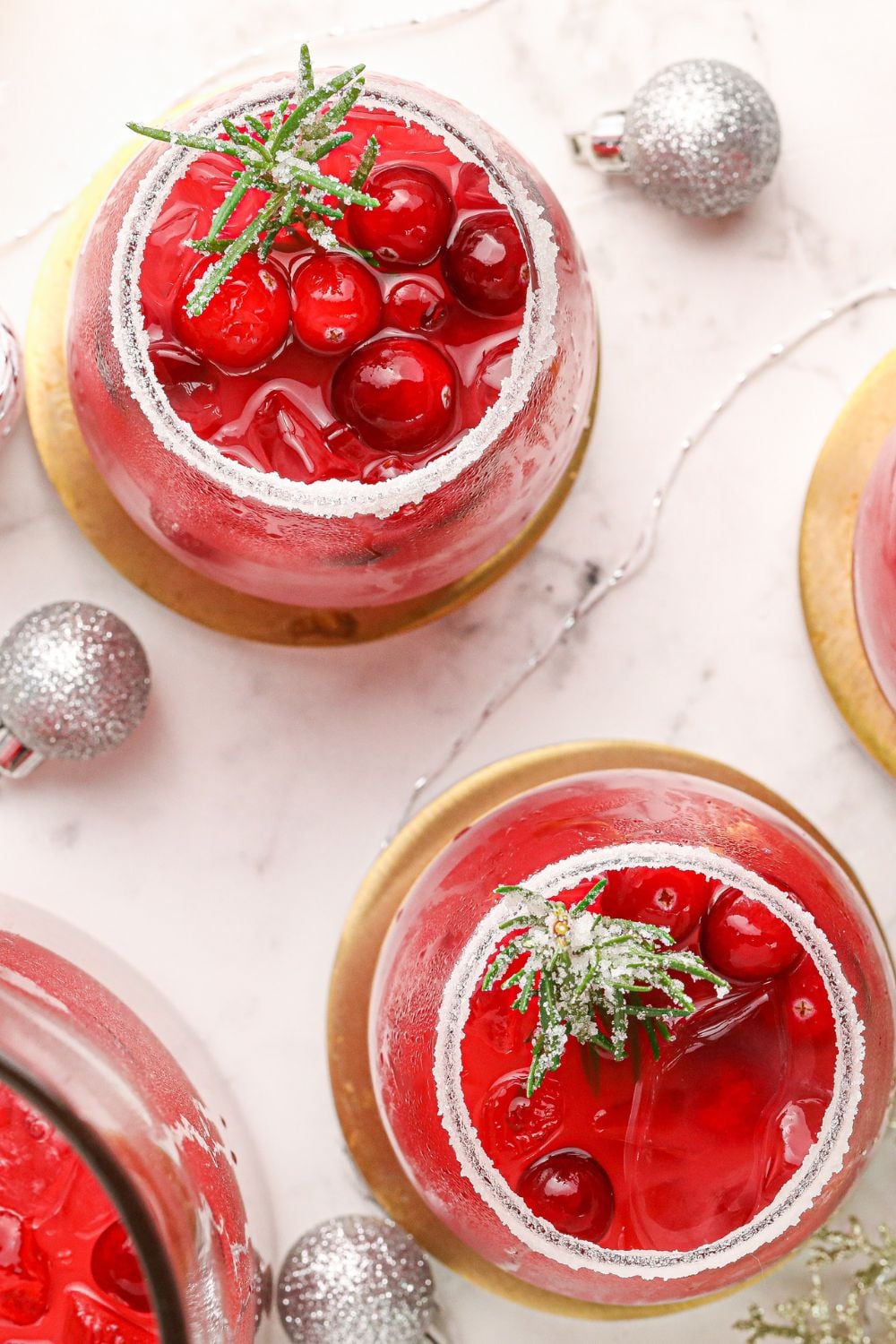 cranberry margaritas in glasses with Christmas ornaments around the table