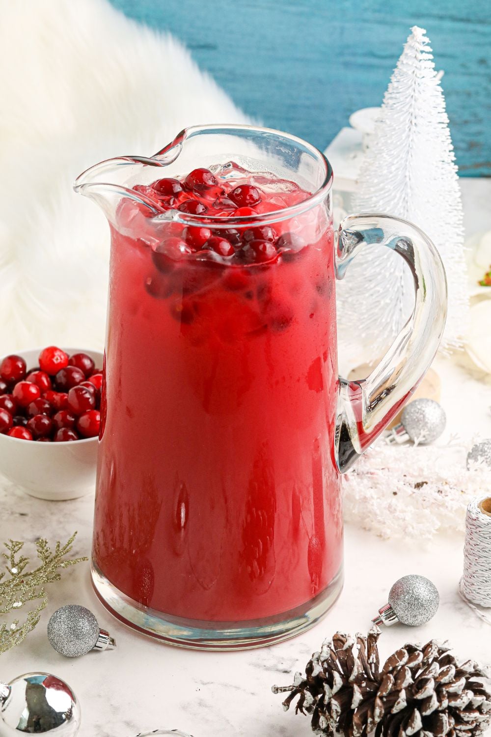 cranberry rosemary margarita mixture in a pitcher on christmas decorated table