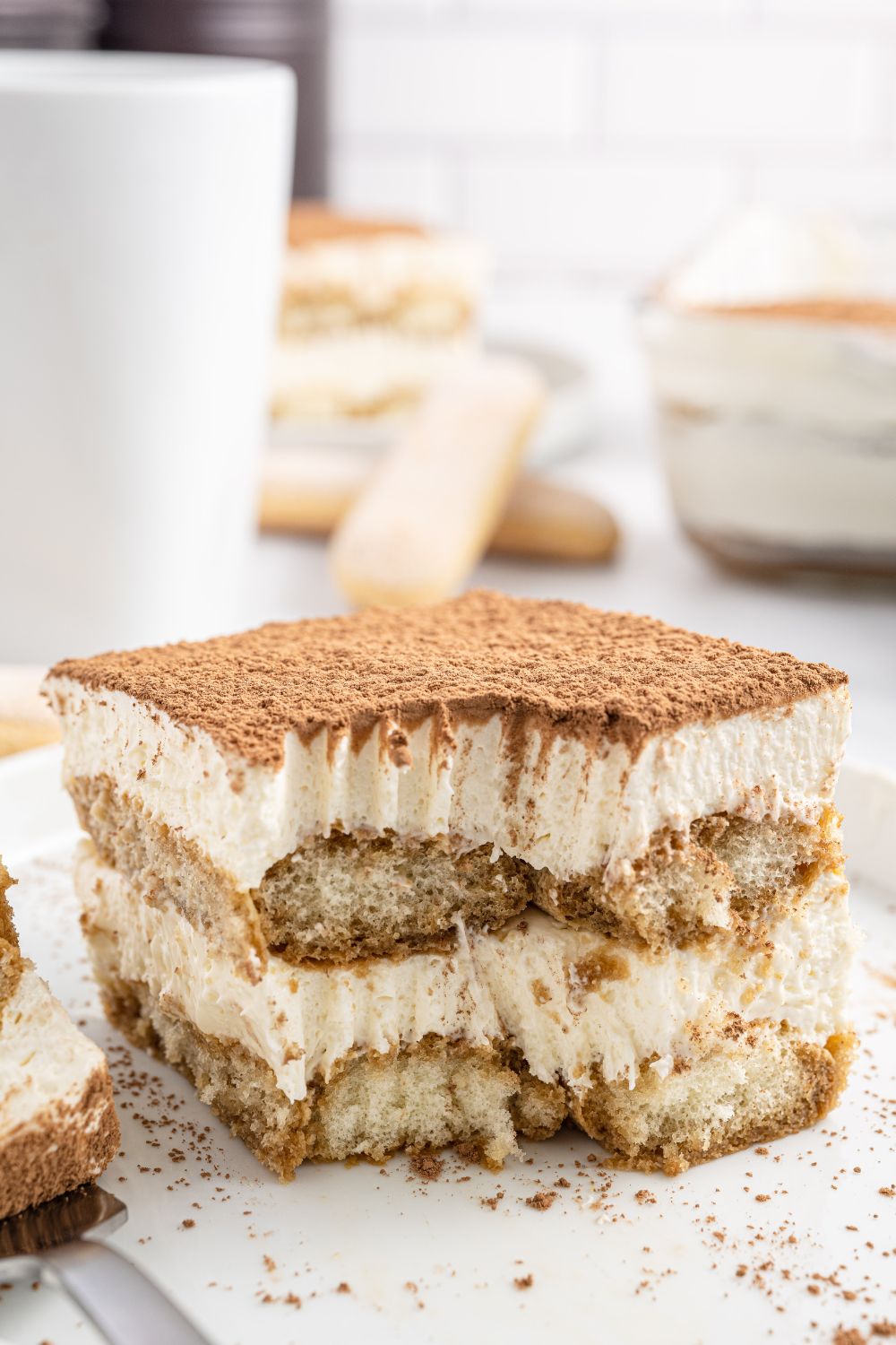 bite taken out of a slice of tiramisu on plate