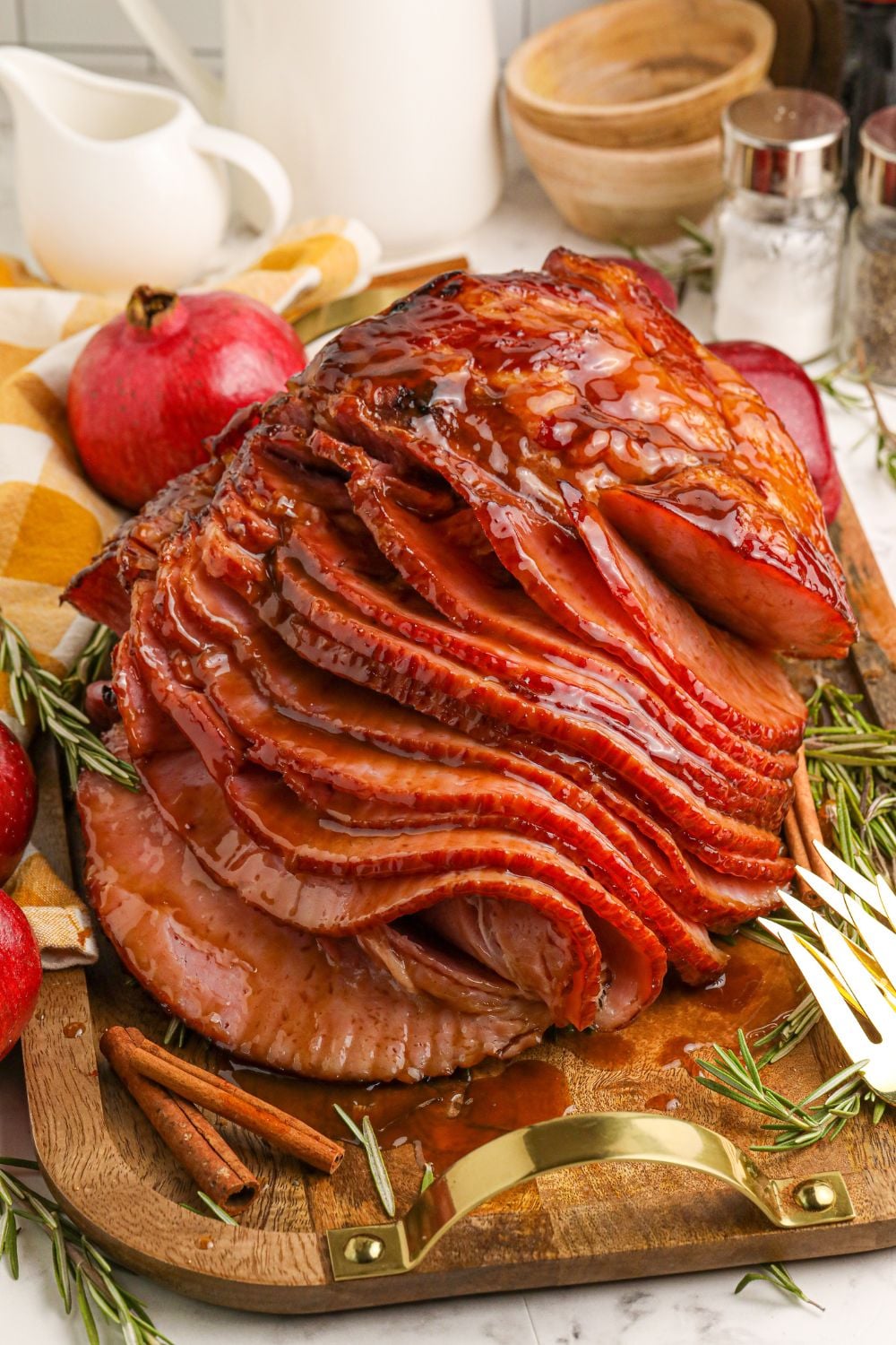 sliced ham on table with forks on edge of cutting board