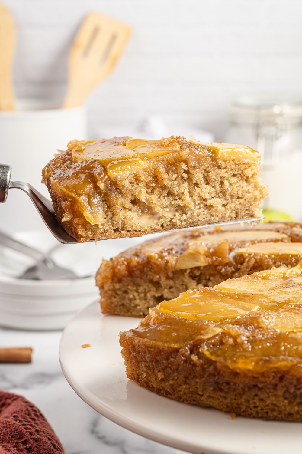 cake on a platter with a slice of cake on spatula