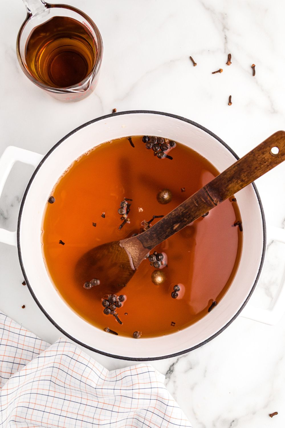 cider in a pot on table with a wooden spoon in it
