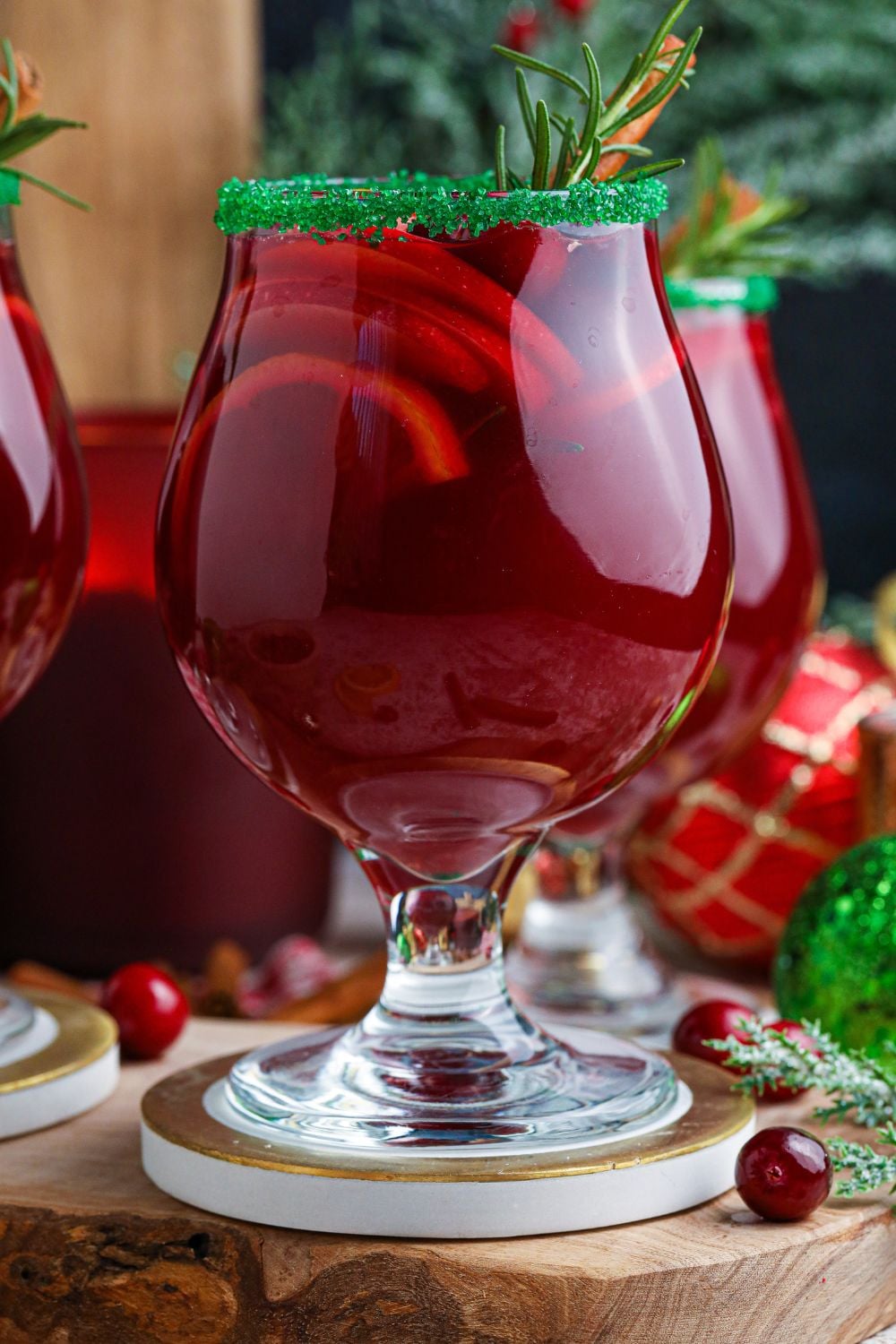 side view of glasses of Christmas cocktails sitting on coasters
