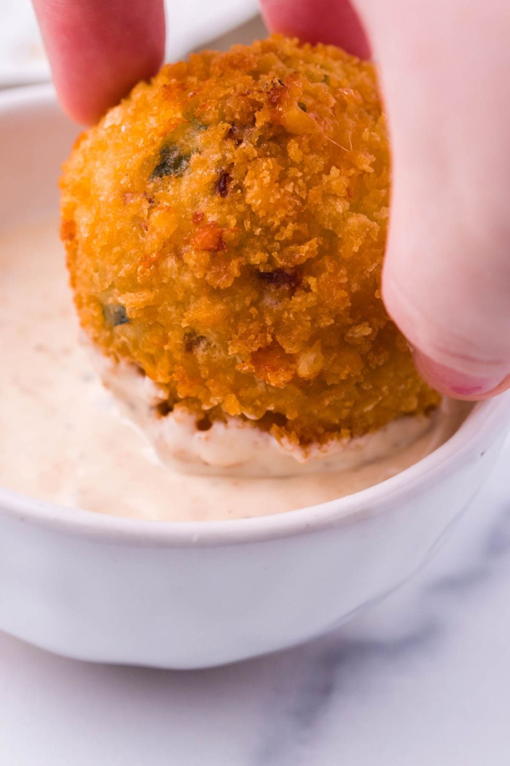 Jalapeno Popper Bite being dipped in sauce