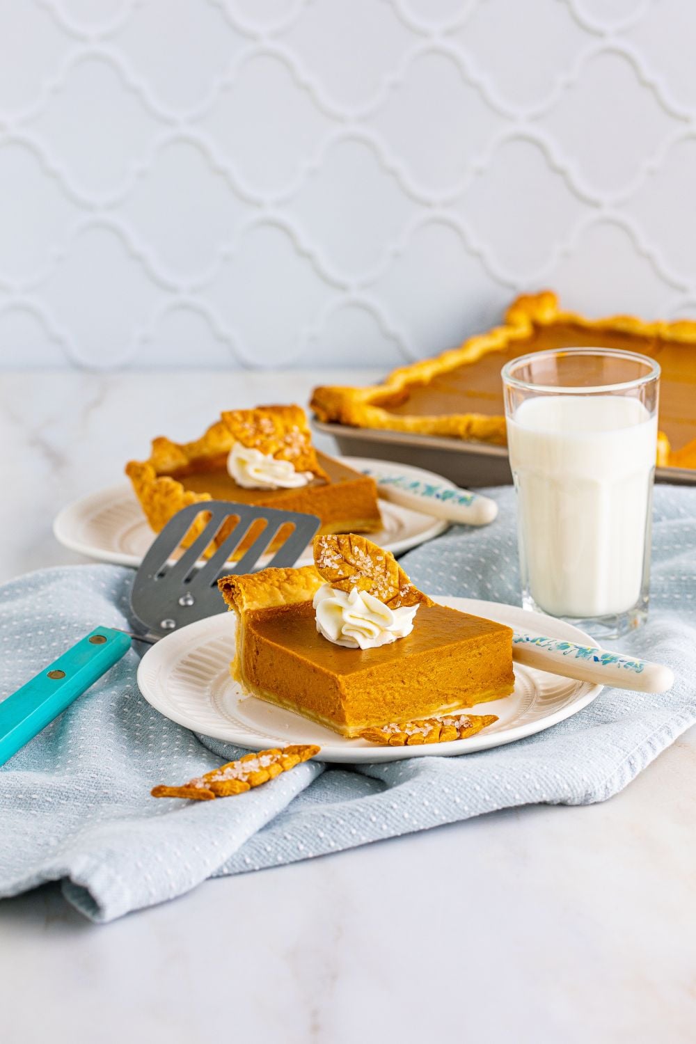 Pumpkin Slab Pie in background and pie slices on plates with milk 