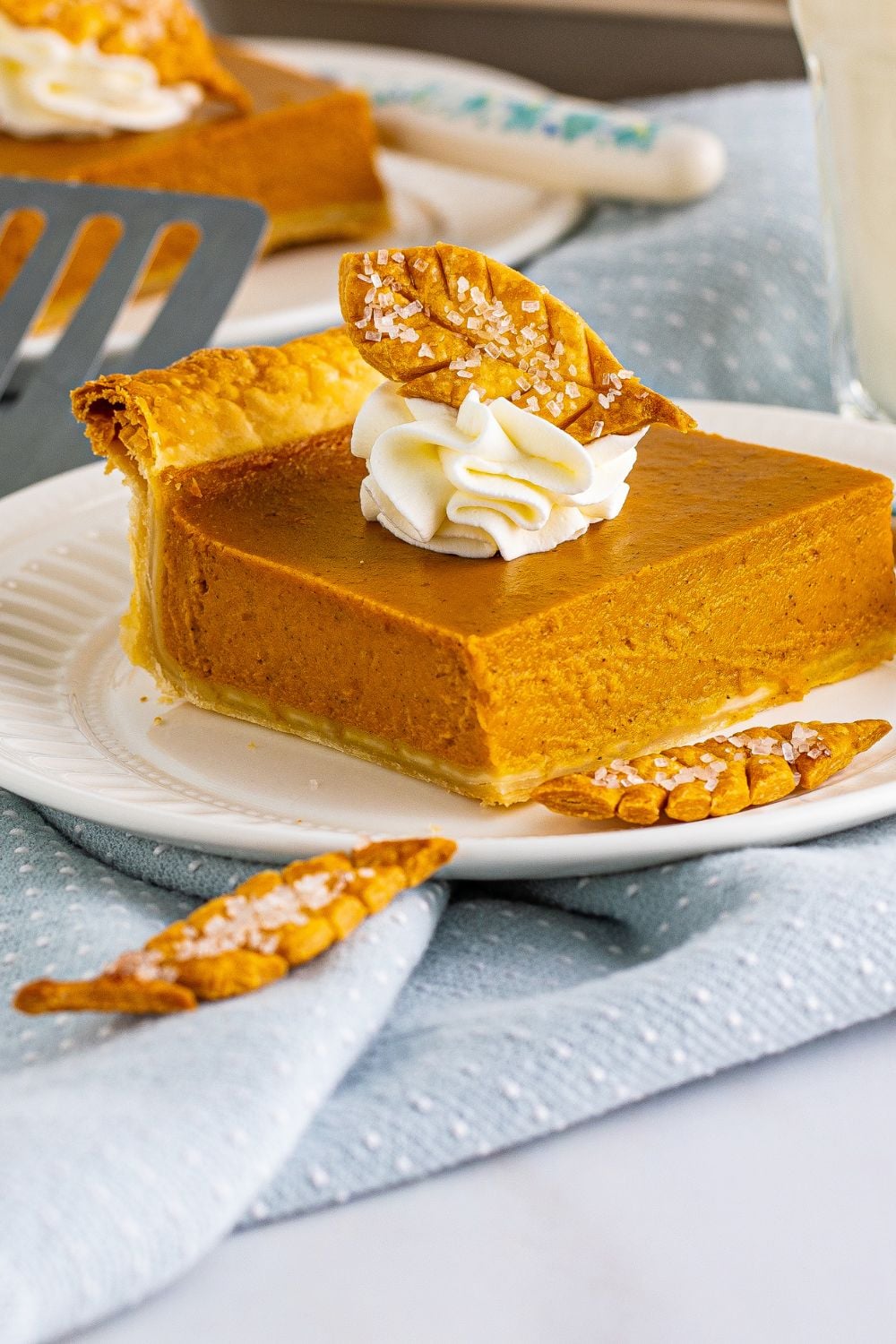 pumpkin pie on plate with crust shaped like leaves