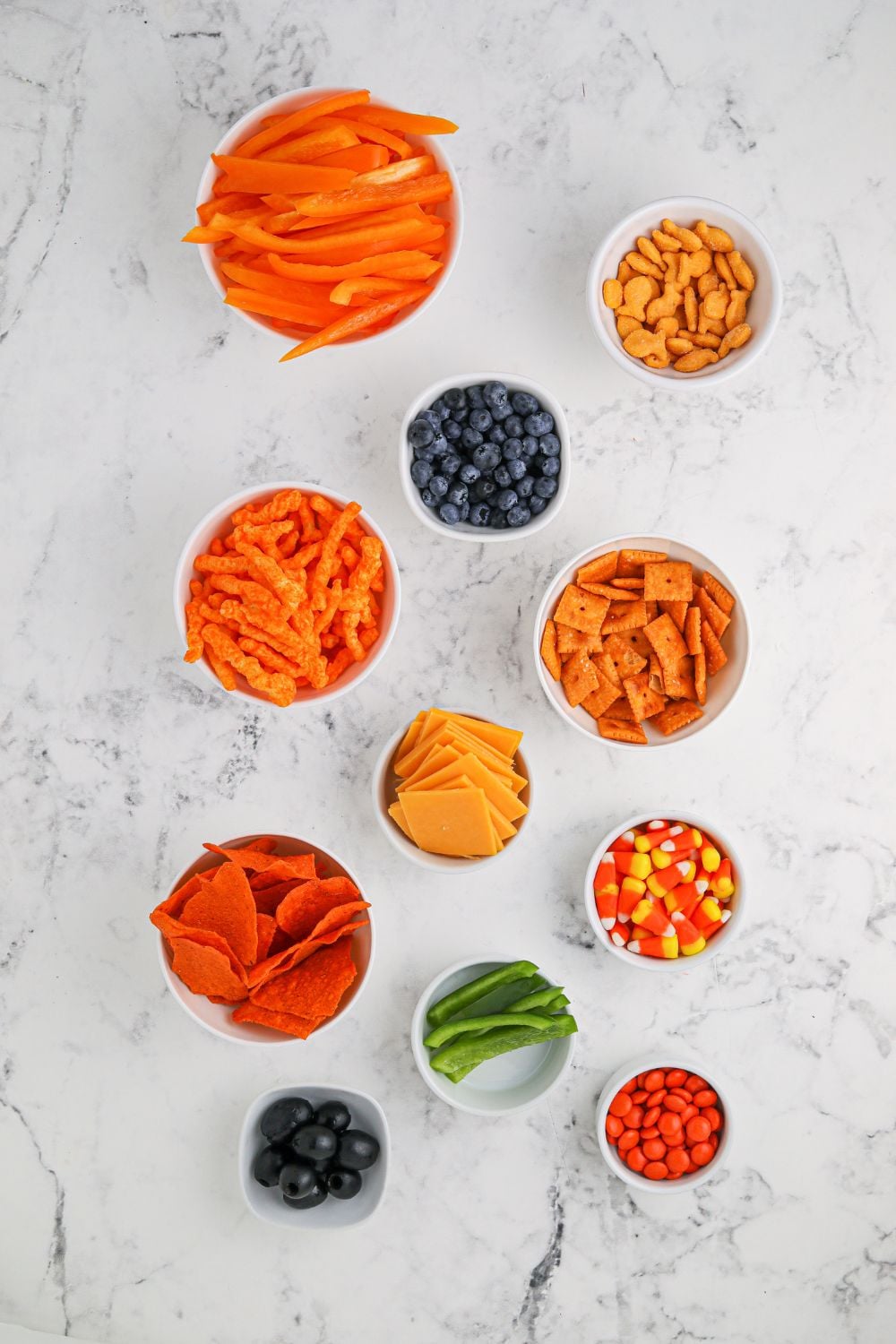 Pumpkin Charcuterie Board ingredients in small bowls on table