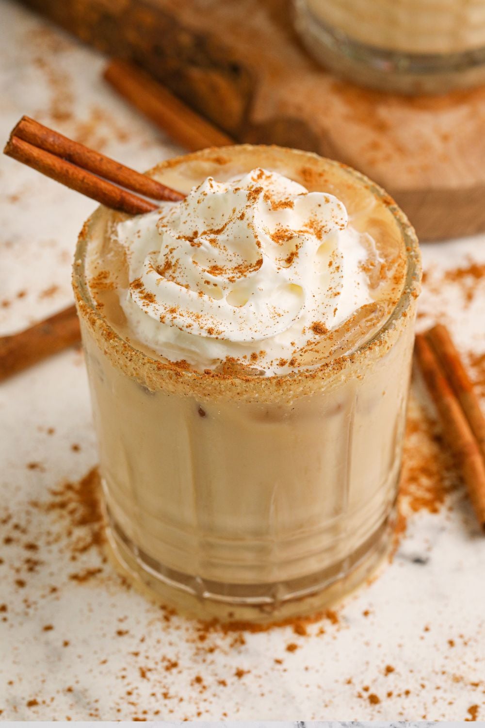 Pumpkin White Russian in glass with cinnamon stick in side and whipped cream 