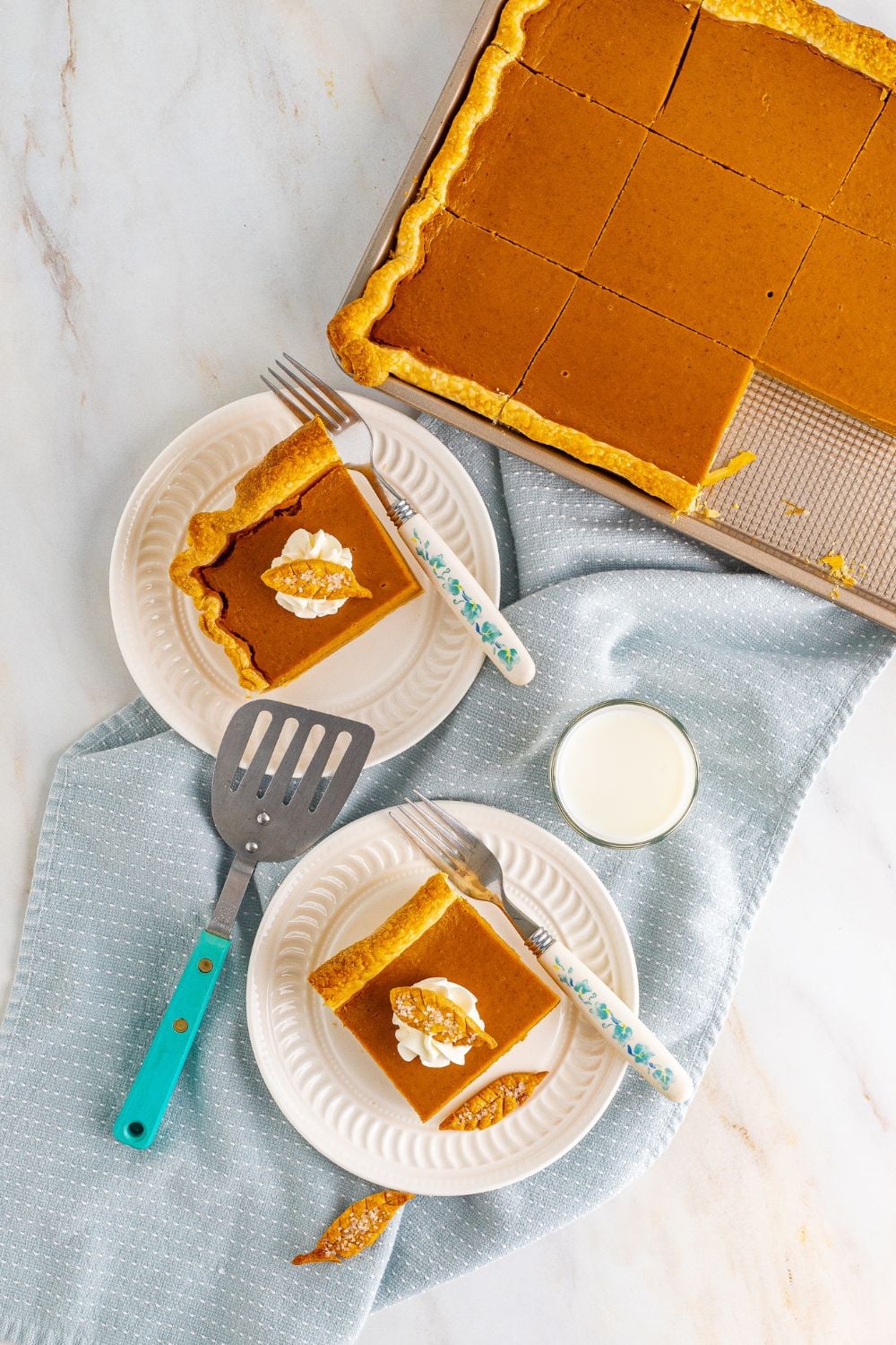 overhead shot of slab pumpkin pie in pan and a few slices on a plate 