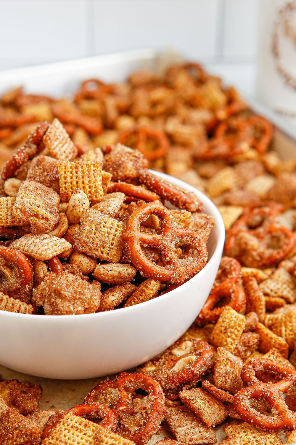 sweet chex mix in tray with bowl of sack mix