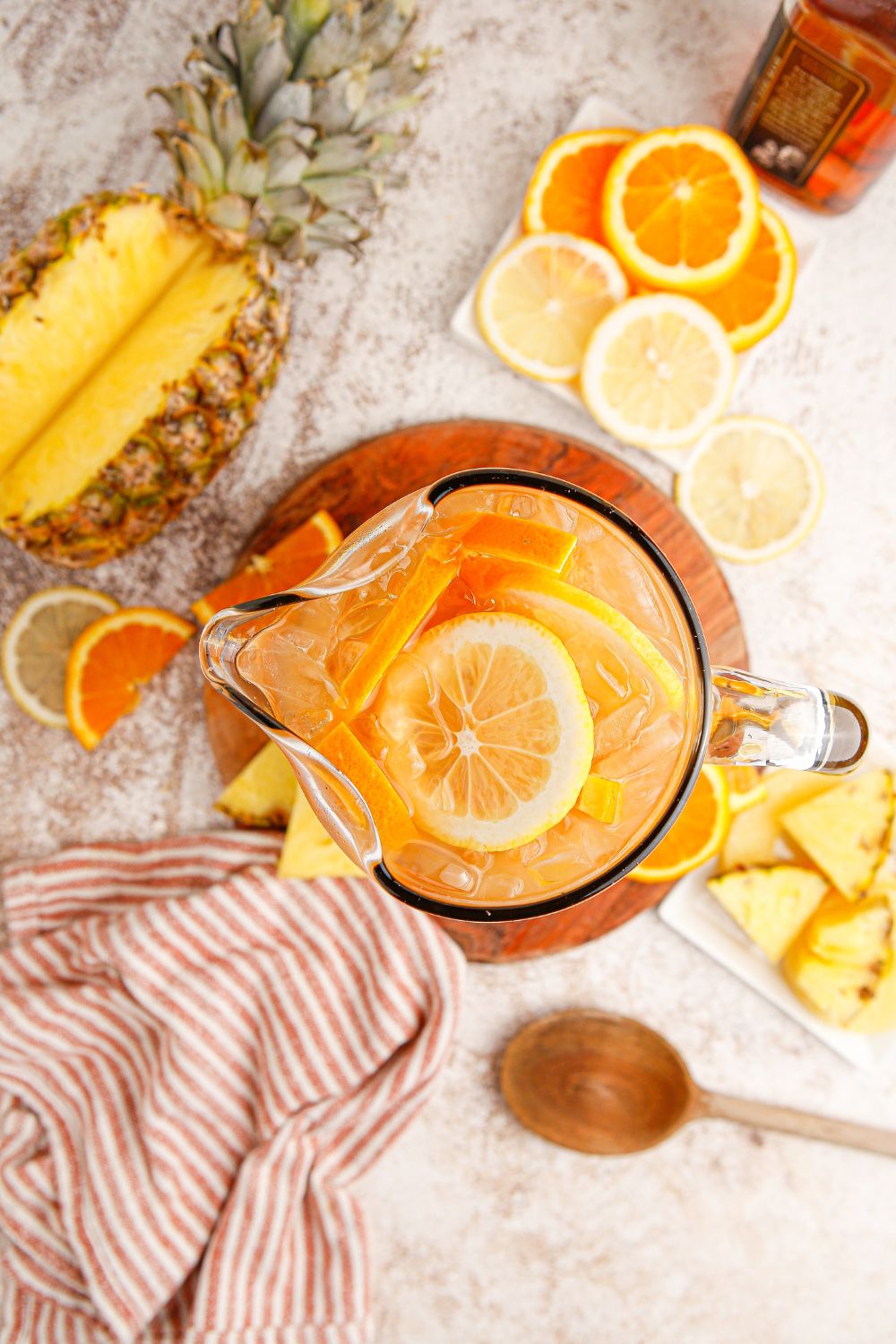 sweet tea with borbon in serving pitcher and fruit around it