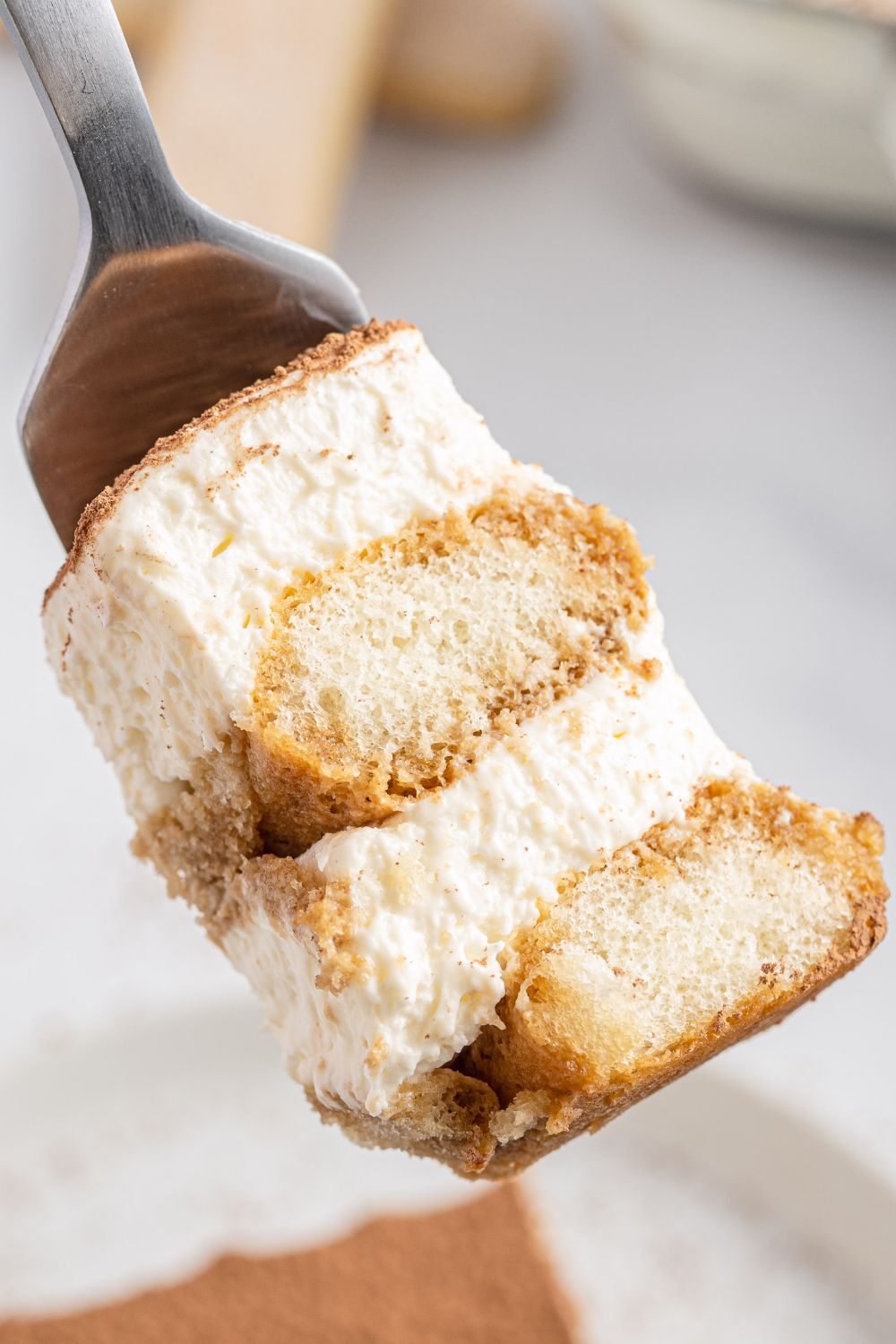 tiramisu bite on a fork above plate