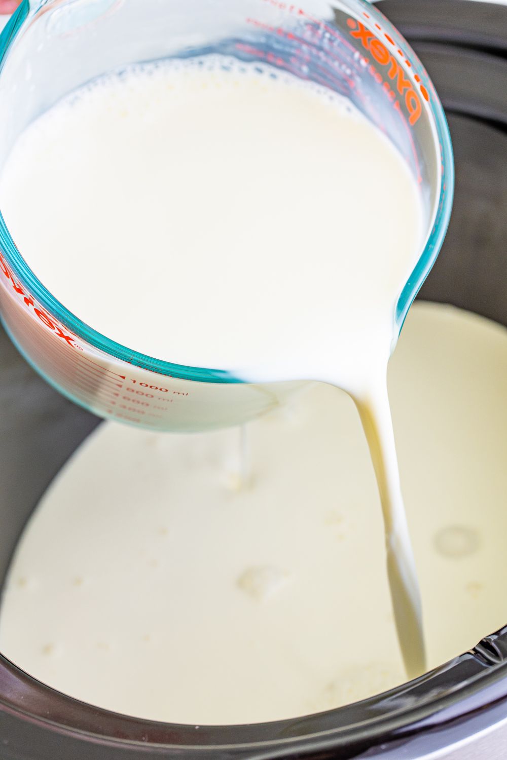 pouring milk into slow cooker