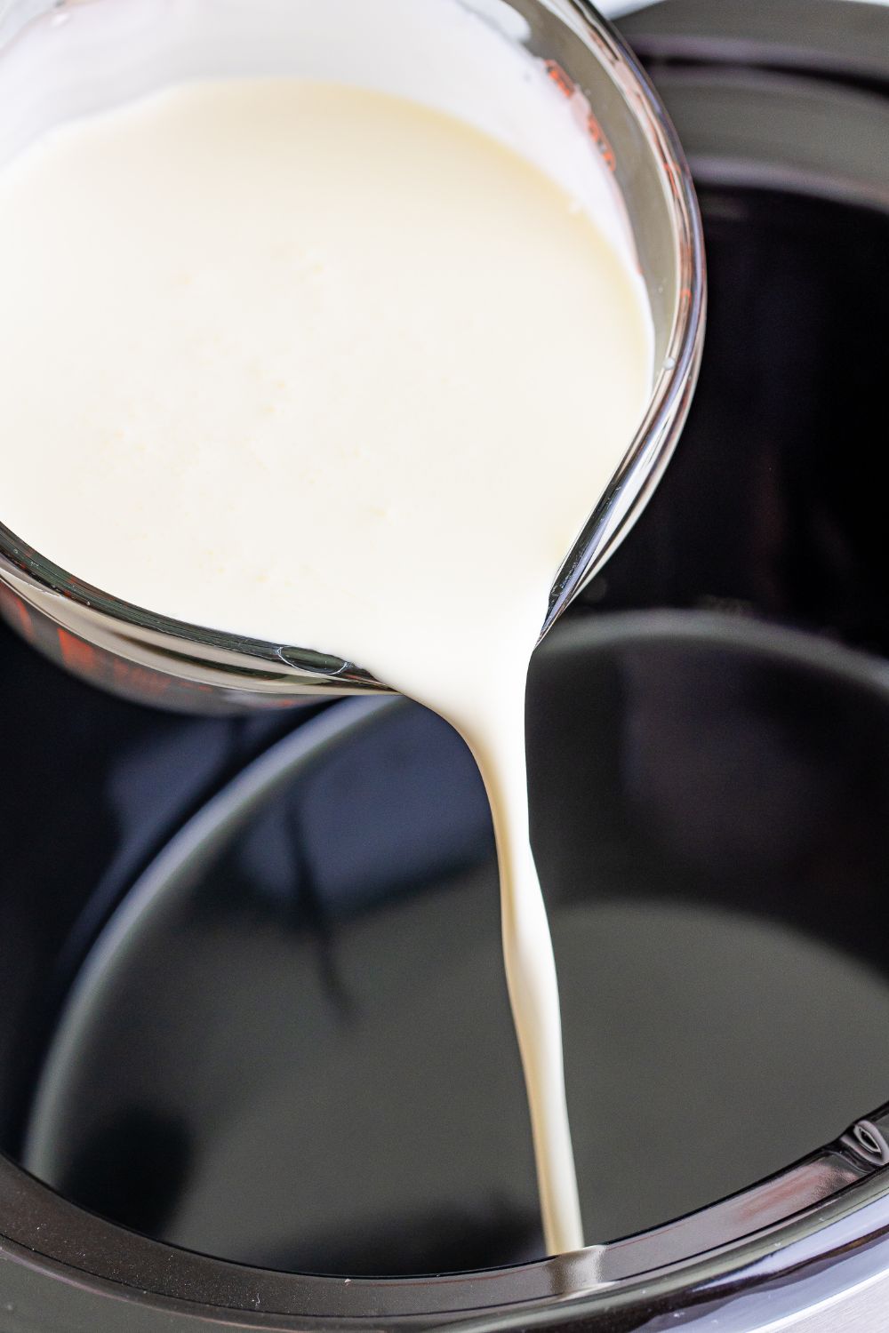 pouring heavy cream into slow cooker