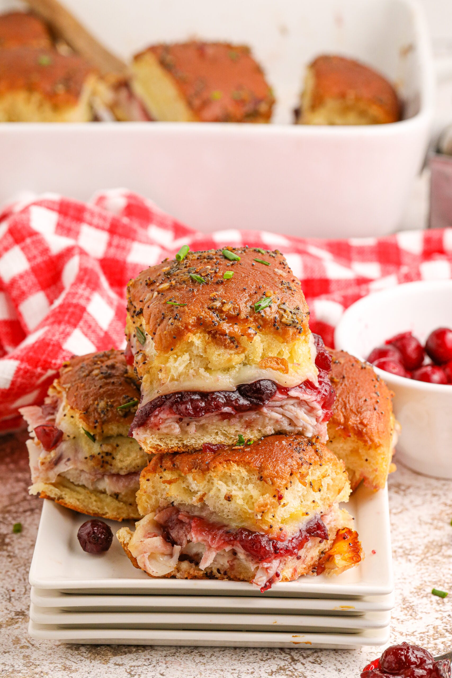 Thanksgiving Sliders stacked on white plates on table