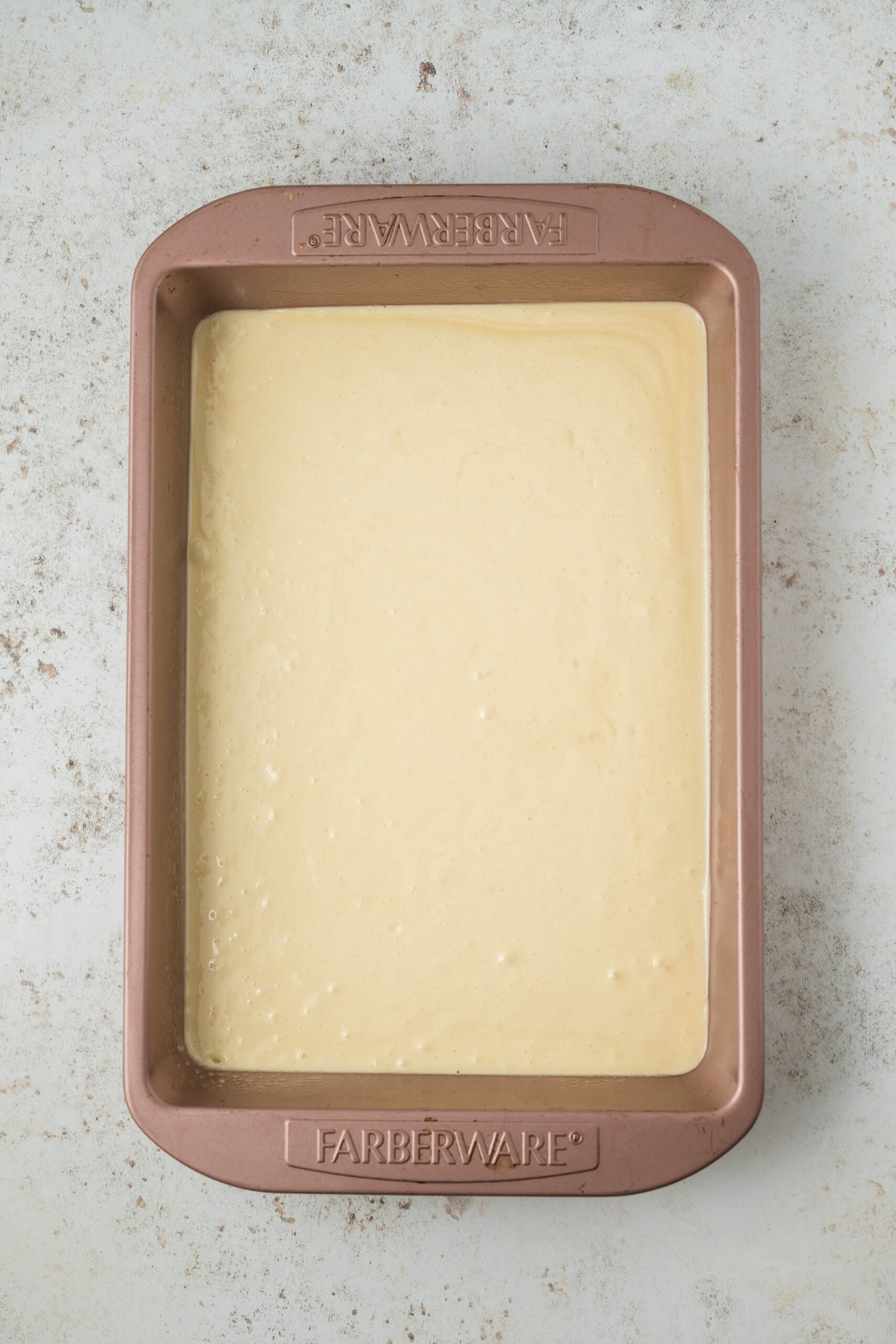 raw cake batter in a baking pan