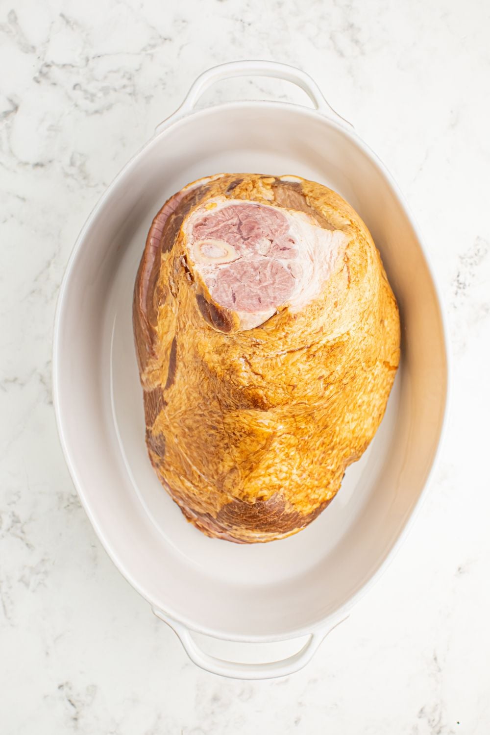 raw ham in a baking dish on table